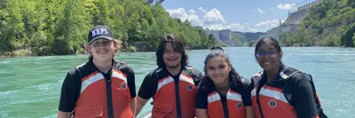 Four students on a boat in a river