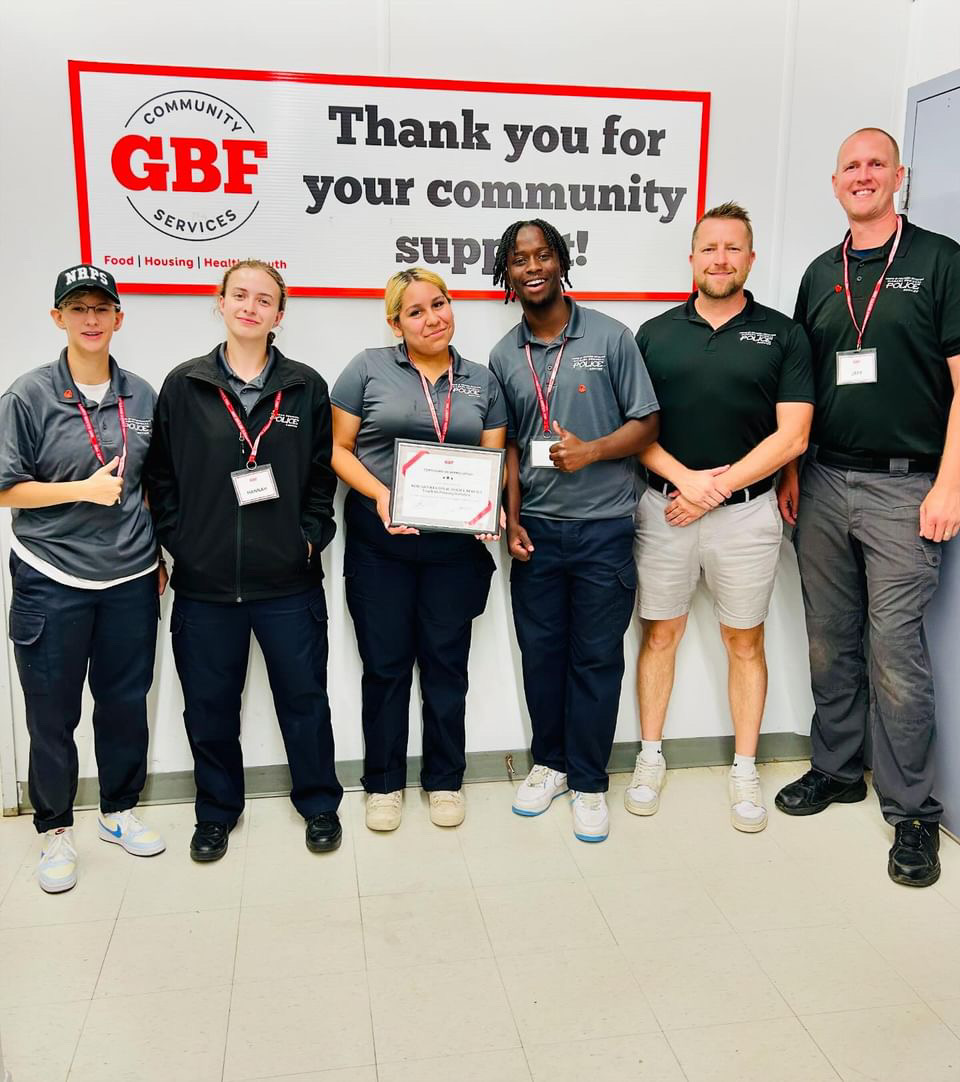 A group of students in front of a sign for Grimsby Benevolent Fund